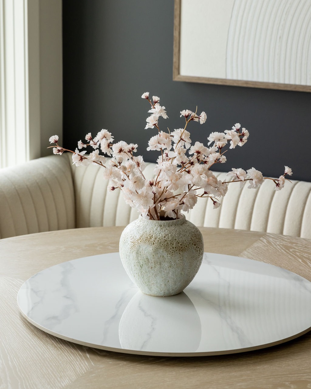 Minimalist dining table styled with a ceramic vase and soft floral arrangement in a modern Omaha home interior
